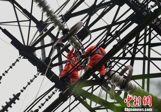 圖為電力工人在70多米高空作業(yè)，為特高壓復(fù)奉線重慶段進(jìn)行八年來(lái)首次大修。　周毅 攝